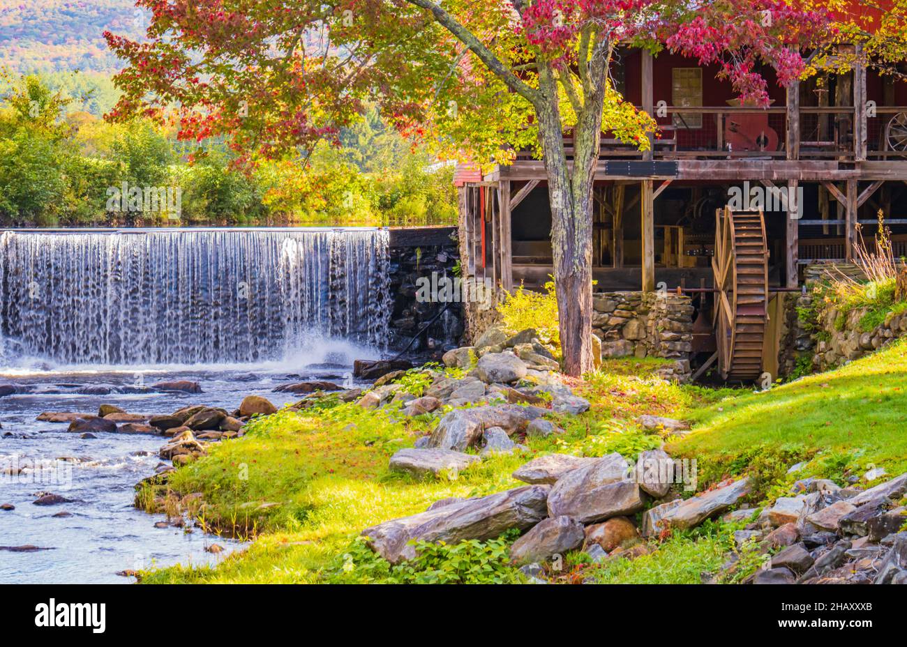 beautiful setting of the old Mill Museum, water wheel, millpond and waterfall on the West River in historic Weston Village in Vermont Stock Photo