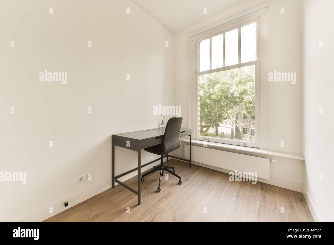 Interior of empty room with whitewash walls and laminated floor and