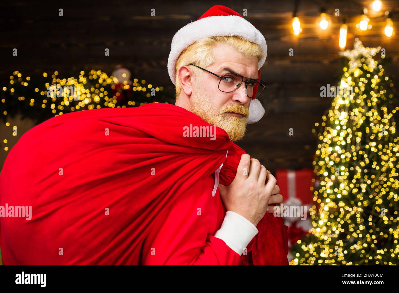 Santa Claus carrying red bag with presents. Delivery christmas gifts. New year advertising Stock Photo