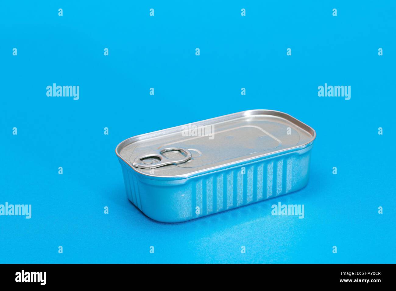 Unopened Tin Can with Blank Edge on Light Blue Background. Canned Food
