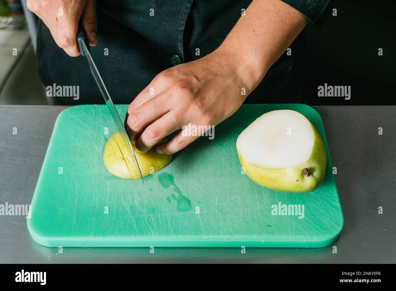 Pear Chef Slicing pear in kitchen sharp hi-res stock photography and images - Alamy
