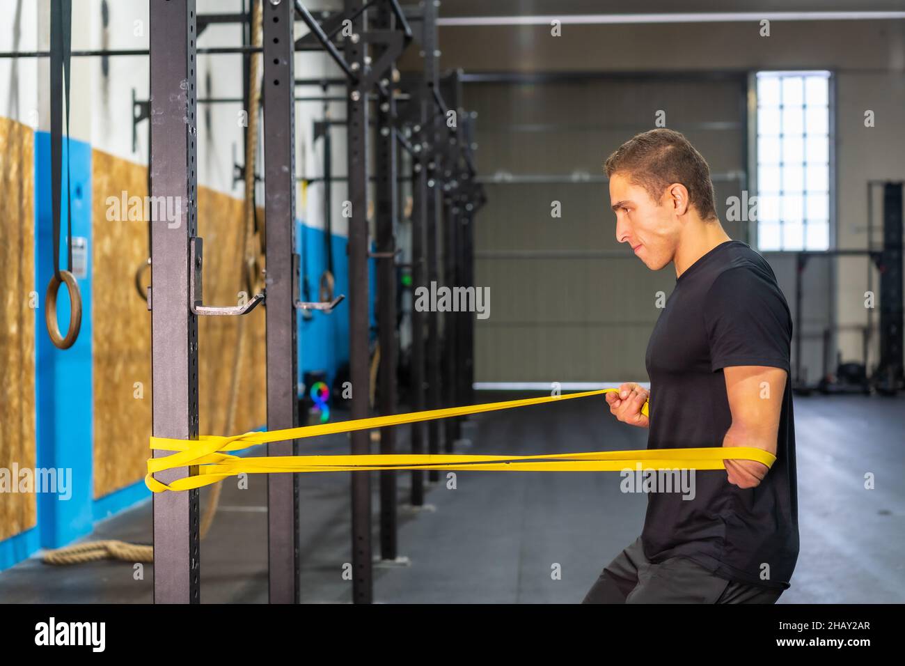 Side view of male athlete with amputated arm stretching resistance band