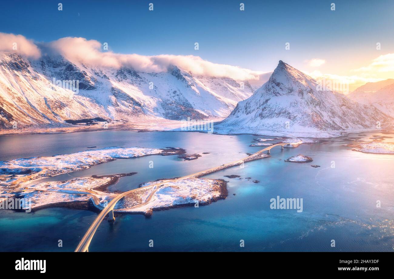 Aerial view of bridge over the sea and snowy mountains Stock Photo