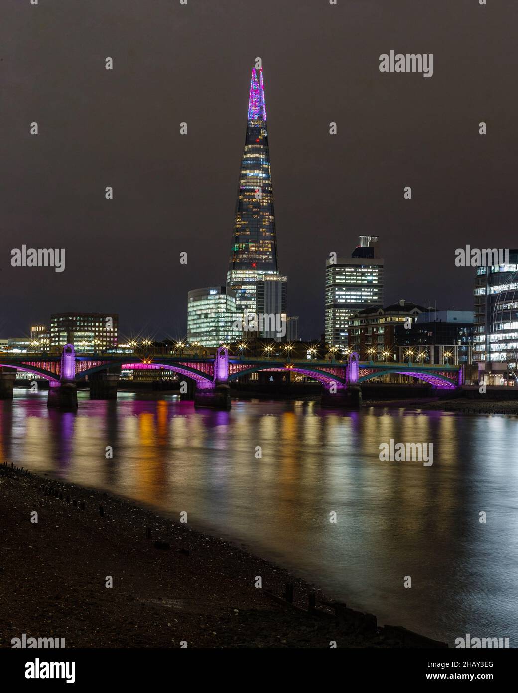 A multicoloured apex of the Shard, and colourful reflections in the Thames during the festive season. Stock Photo