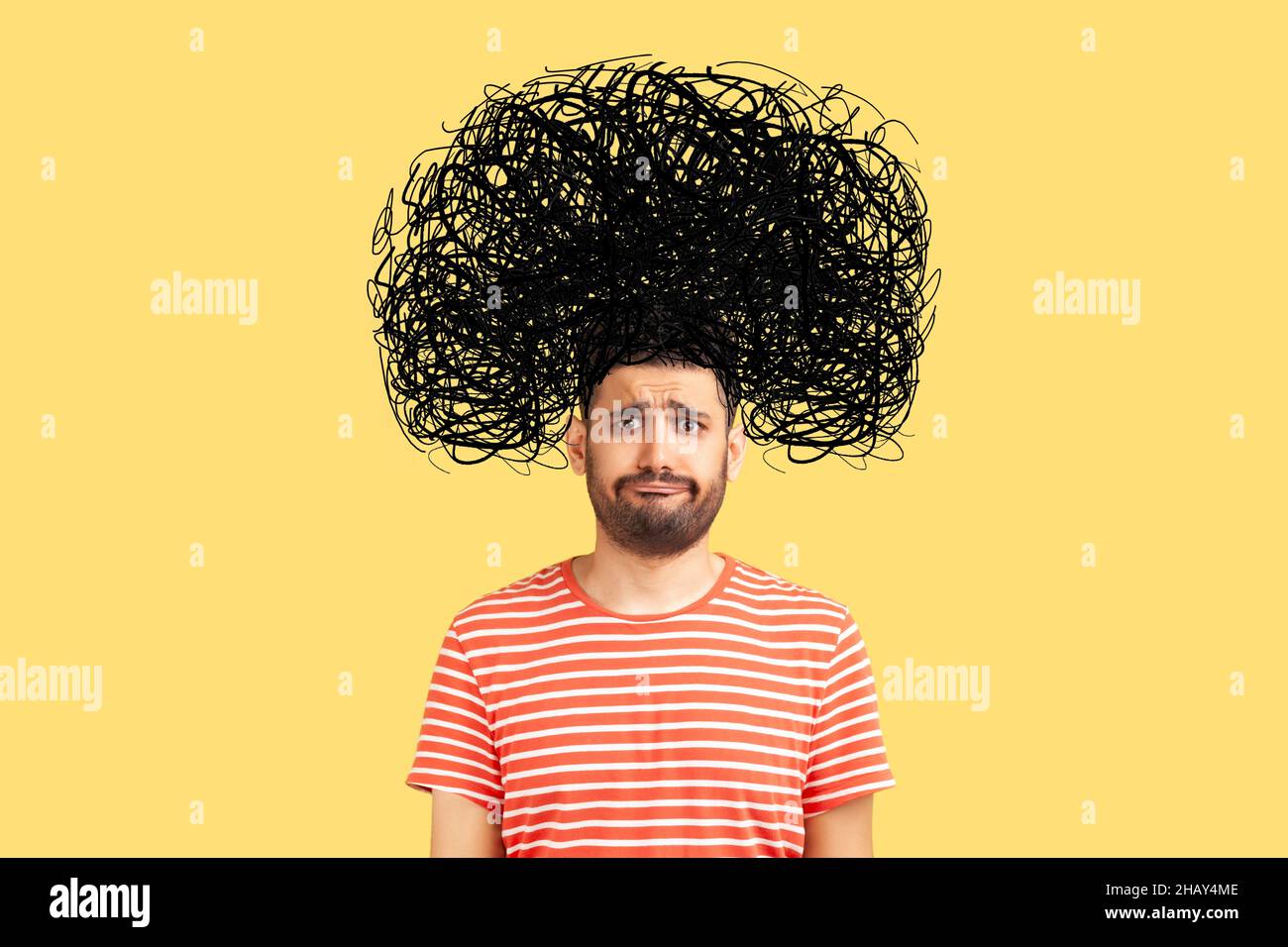 Frustrated man with nervous problem feel anxiety and confusion of thoughts. Mental disorder and chaos in consciousness. Indoor studio shot isolated on yellow background Stock Photo
