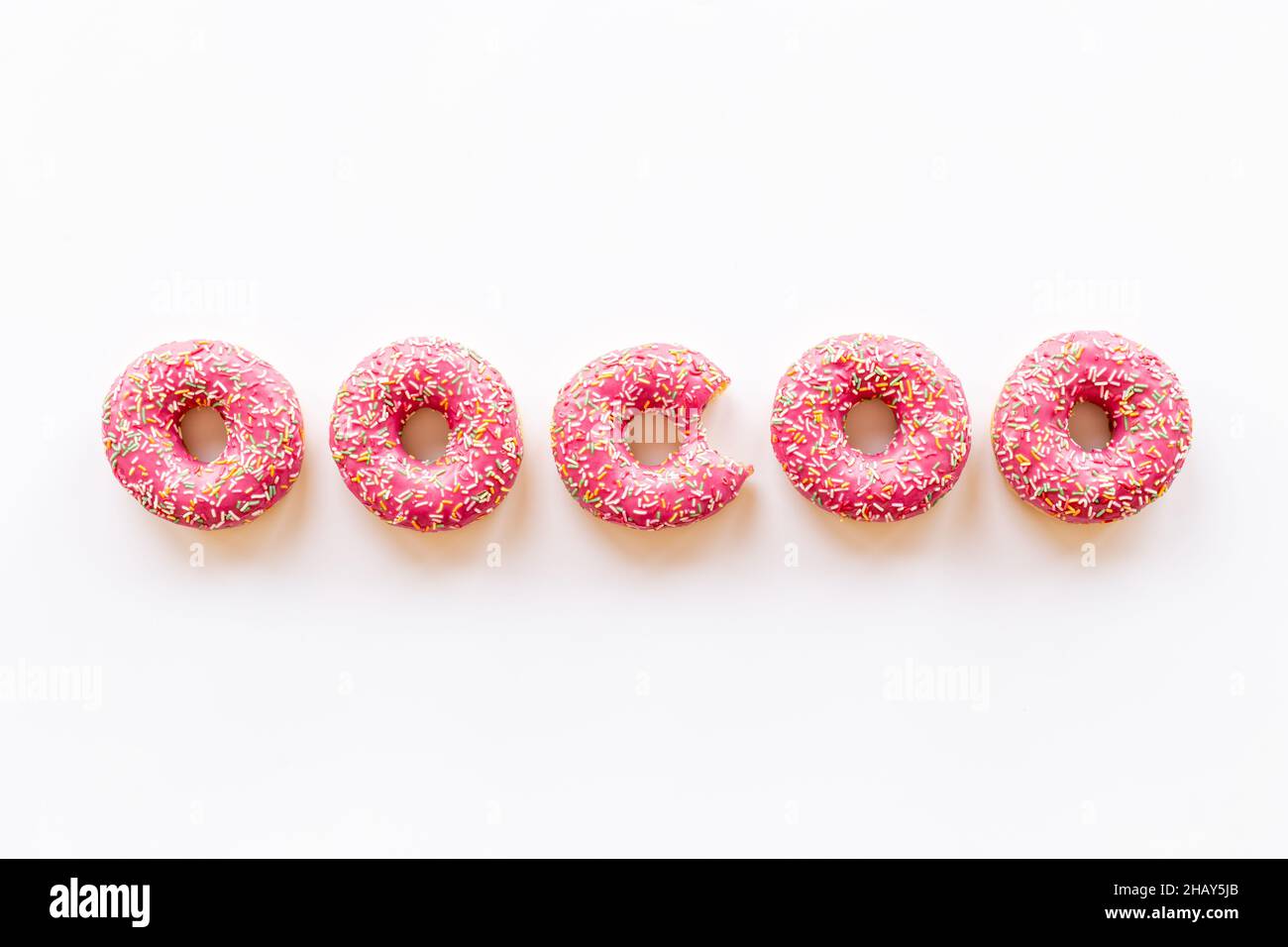 Pink frosted donuts with colorful sprinkles. Bakery background Stock ...