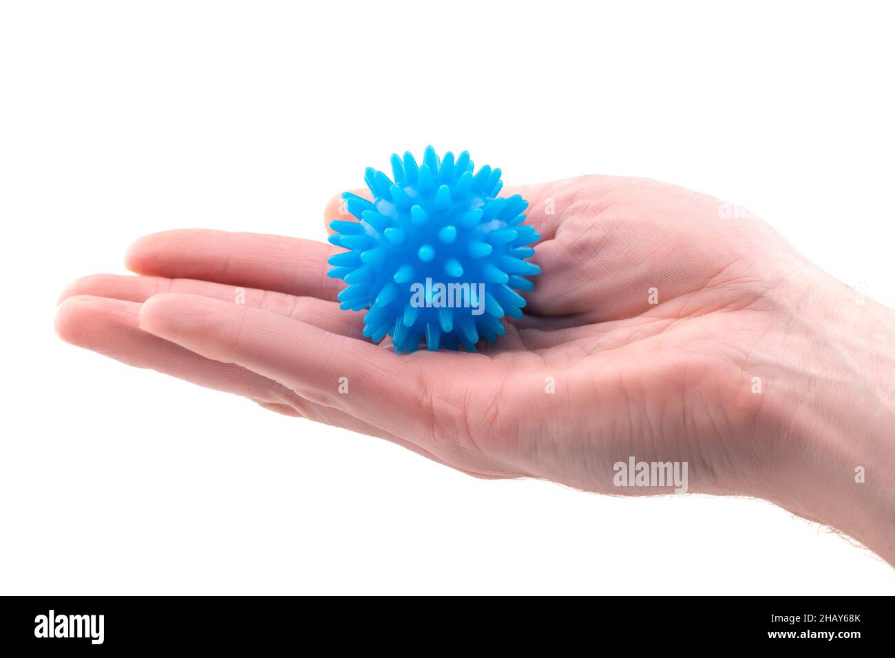 Detail studio shot of blue rubber massage ball lying on palm of a right hand isolated on white background. Contemporary rehabilitation equipment Stock Photo
