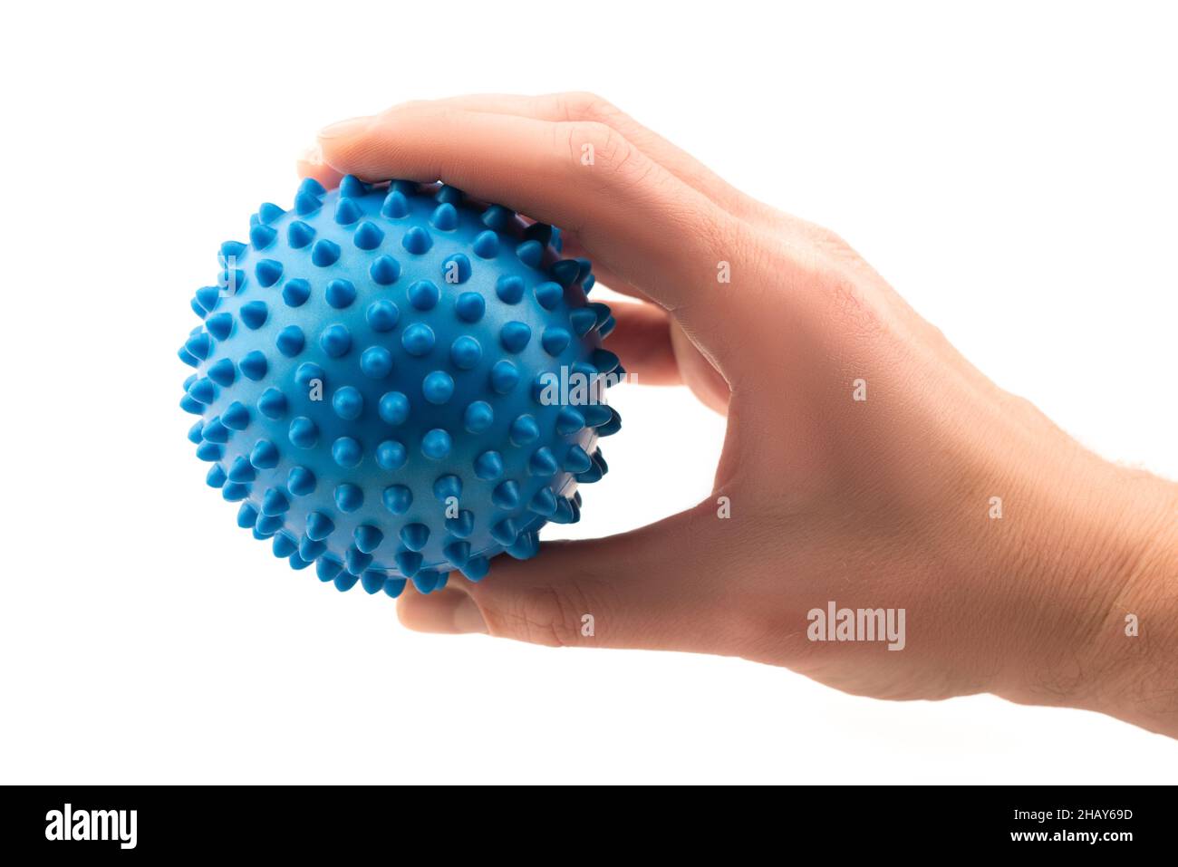 Detail studio shot right hand holding blue rubber massage ball isolated on white background. Contemporary rehabilitation equipment. Physiotherapy Stock Photo