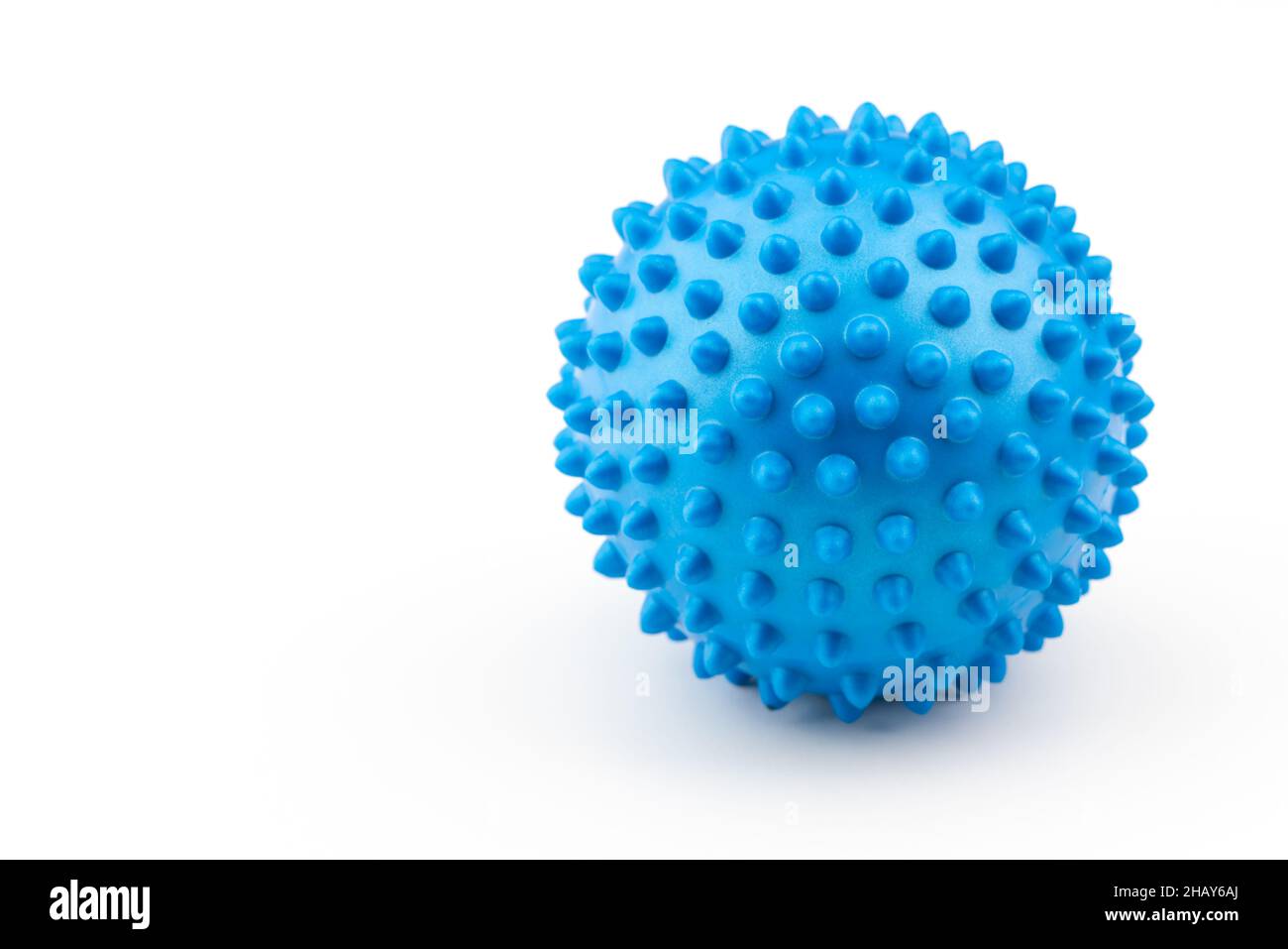 Detail studio shot of blue rubber massage ball isolated on white background. Contemporary rehabilitation equipment. Physiotherapy tools. Stock Photo