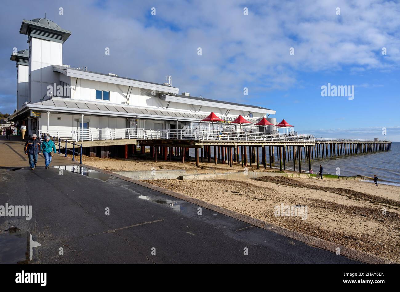 Felixstowe, Suffolk, UK: Felixstowe pier is popular with tourists for its amusement arcade and cafe. Two people walk along the promenade. Stock Photo