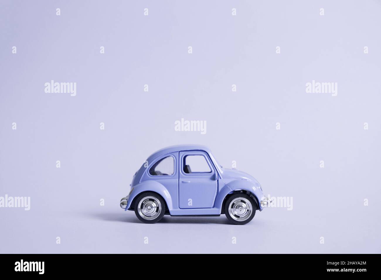 Omsk, Russia - May 26, 2019: Pantone 2022 color retro toy car on blue background. Valentine's day. Flower delivery. 8 March, International Happy Women Stock Photo