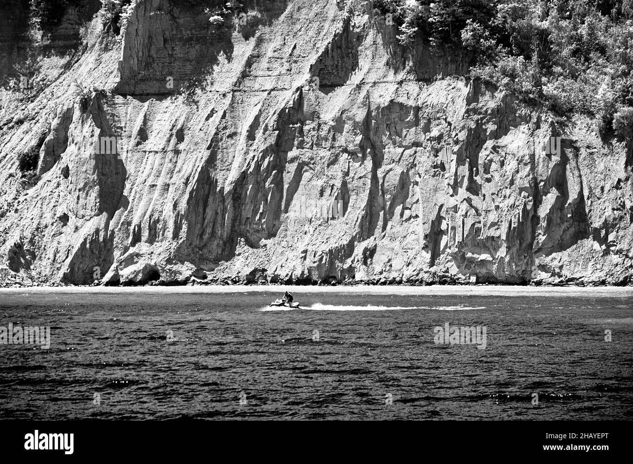 Sun, rocks, water. Speedy scooter in the waters of Lake Ontario at the Scarborough Bluffs Park, the city outdoor destination popular among the Stock Photo
