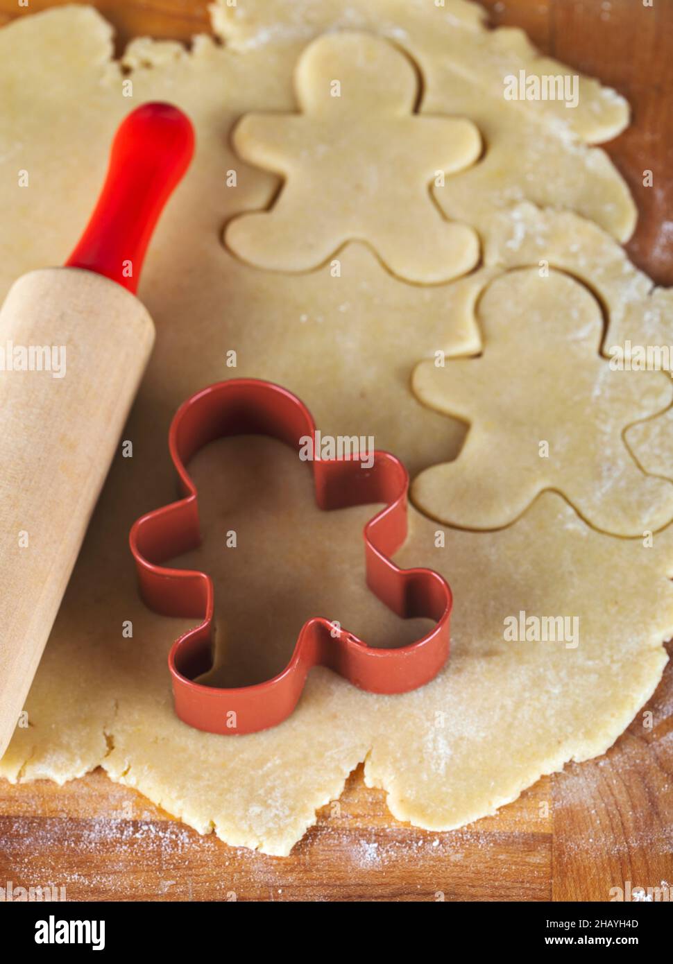 Gingerbread man cookie cutter and rolling pin on cookie dough Stock Photo