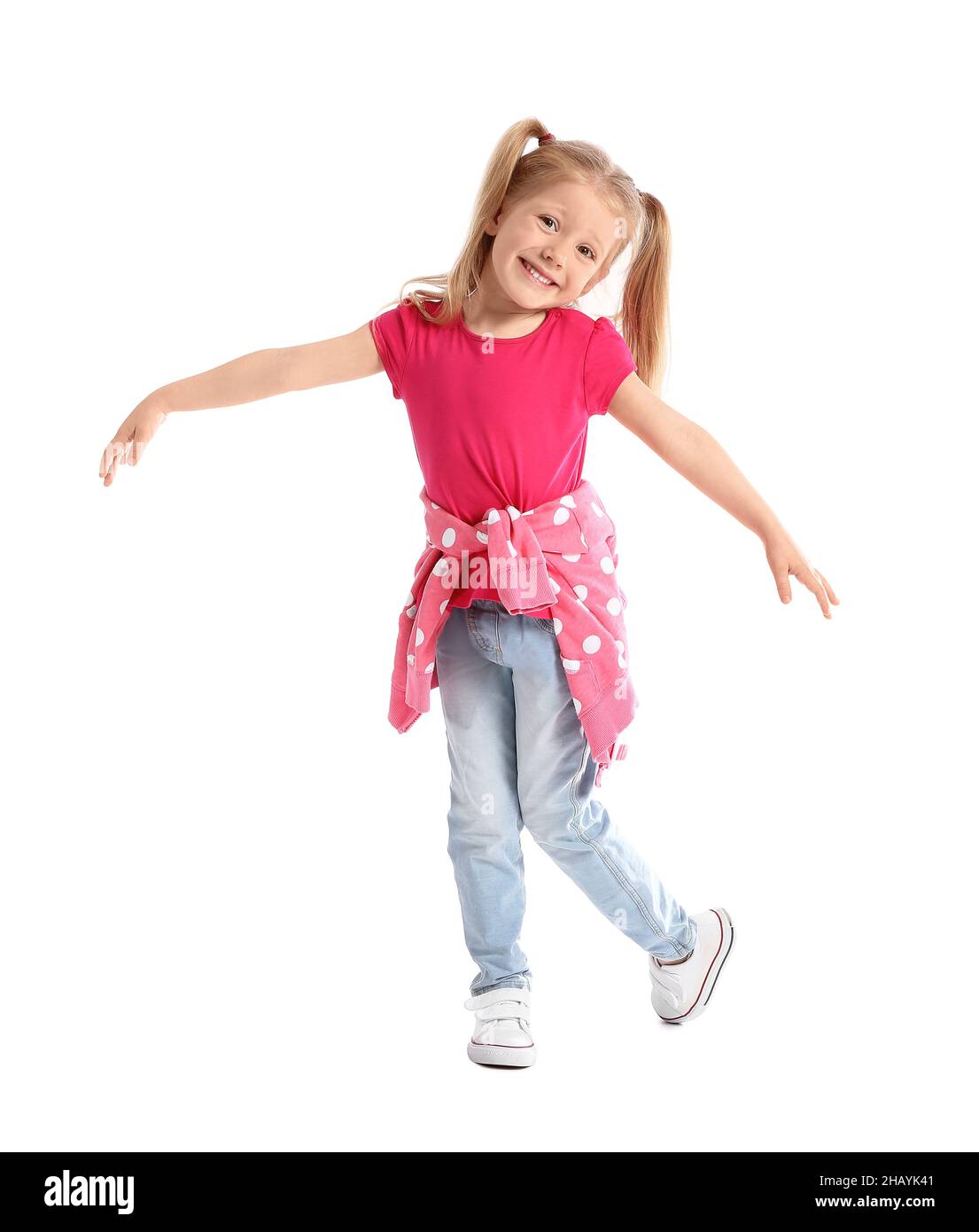 Cute little girl in pink tshirt dancing on white background Stock