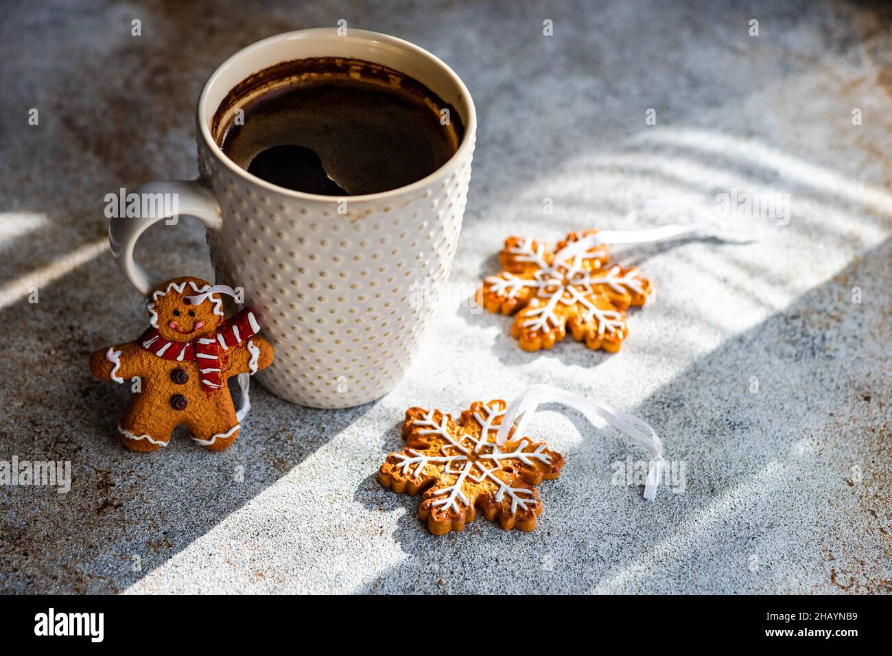 Cup of black coffee, snowflake and gingerbread men Christmas cookies on a  table Stock Photo