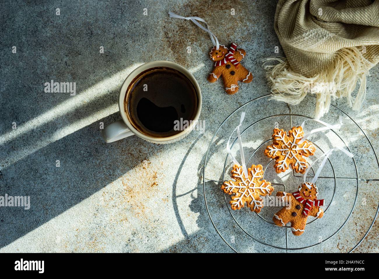 Cup of black coffee, snowflake and gingerbread men Christmas cookies on a  table Stock Photo