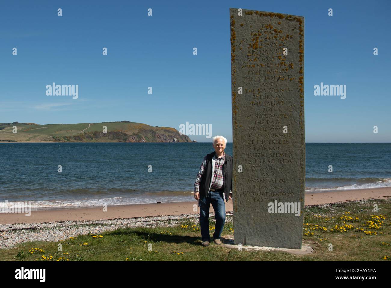Man leaning against Emigration Stone, Cromarty, Highlands, Scotland, UK Stock Photo