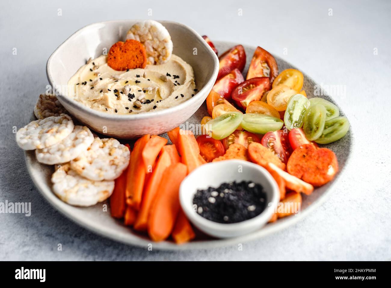 Hummus and vegetables crudites with rice crackers and sunflower seeds
