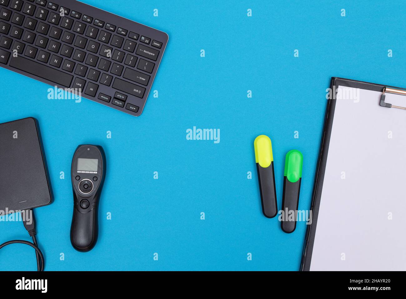 Office Workplace with Digital Gadgets Lying on Blue Table - Flat Lay Stock Photo