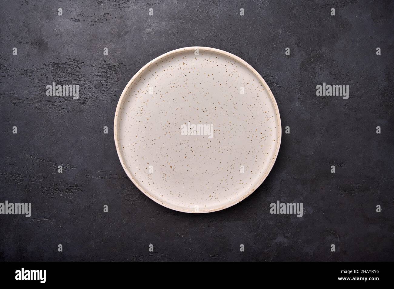 Top view empty white rustic ceramic plate with on black graphite background, copy space Stock Photo