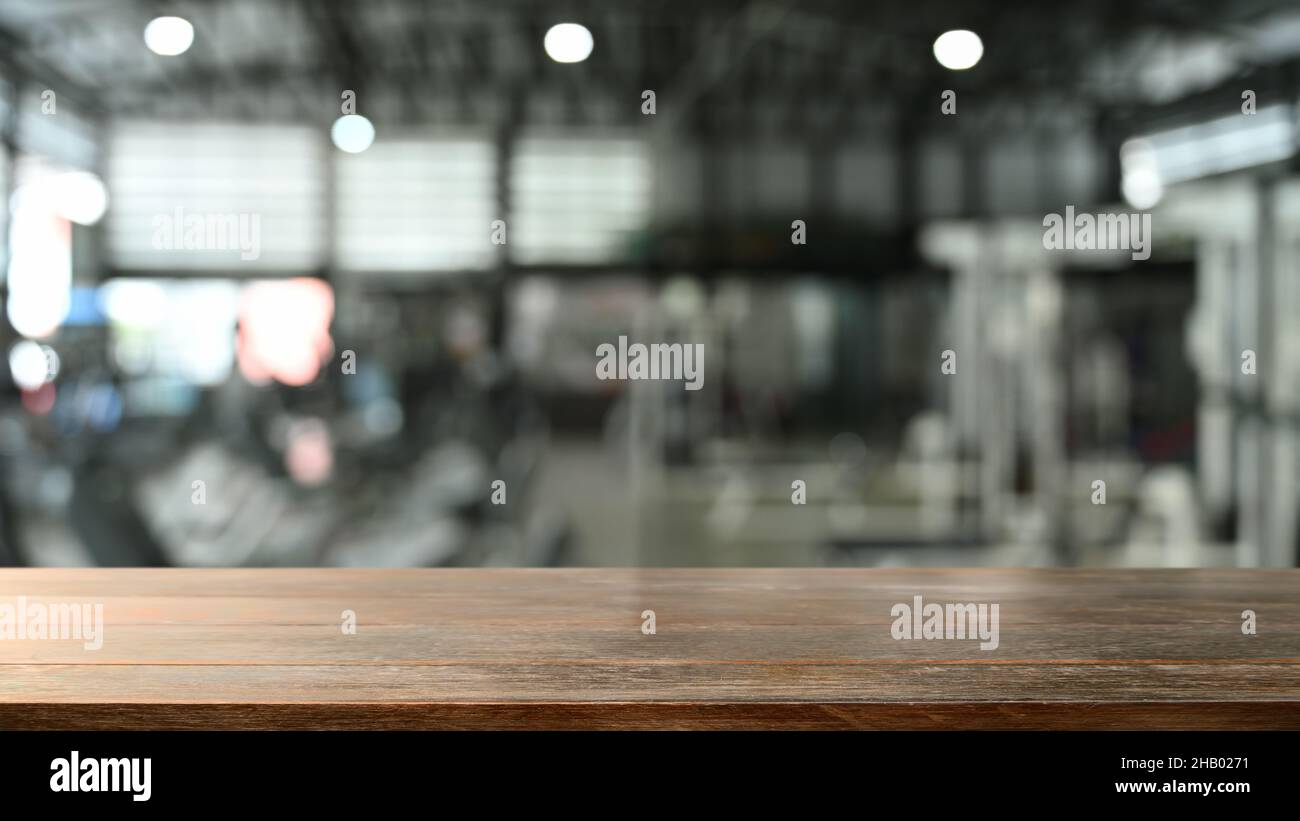 Empty wooden counter with blurred gym in background. For montage your product display. Stock Photo