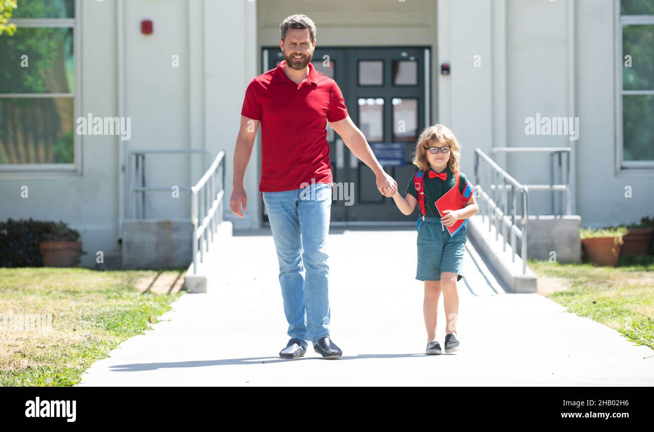 Outdoor school. School boy going to school with father. Parent with