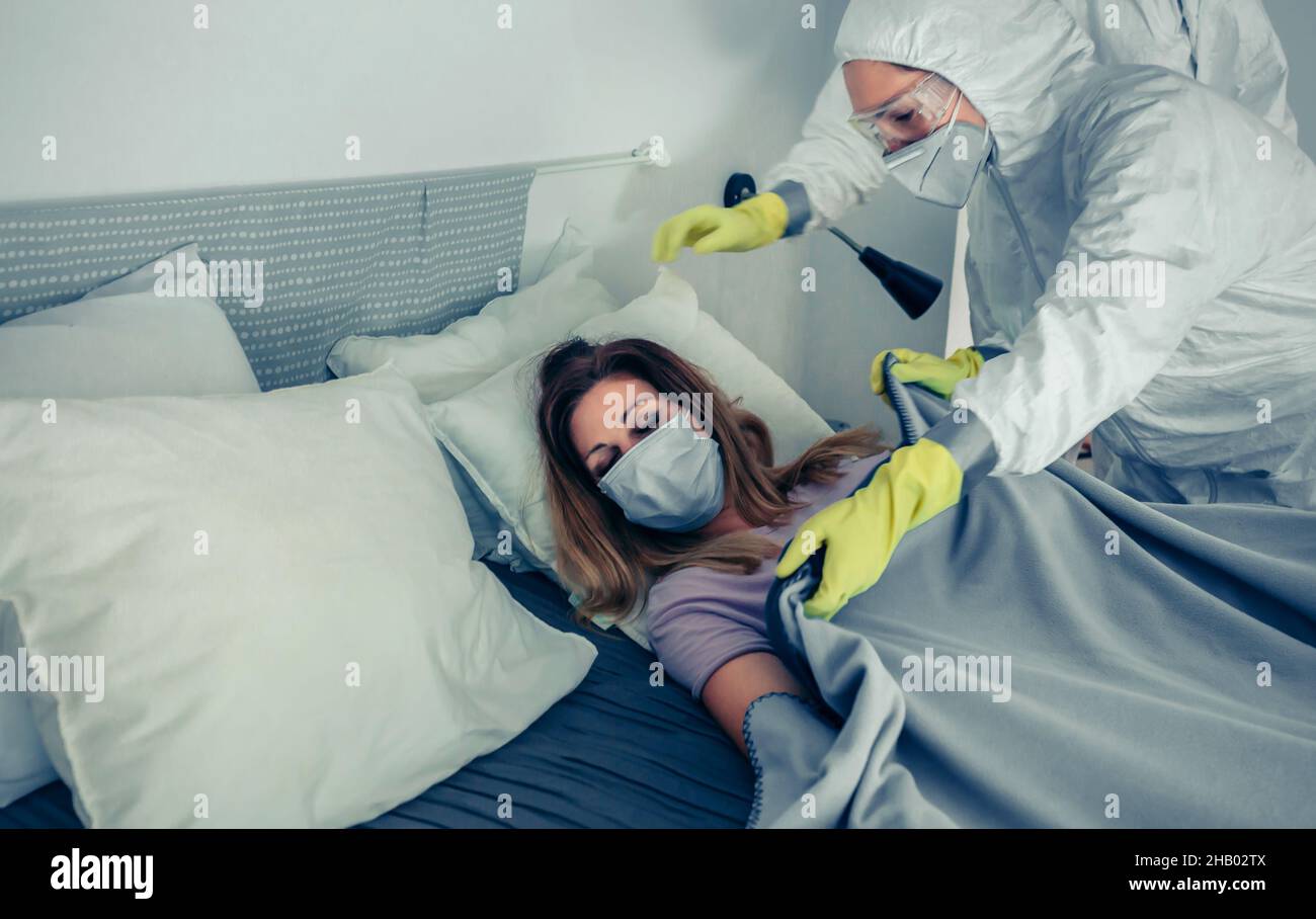 Doctors in bacteriological protective suits caring for a patient Stock Photo