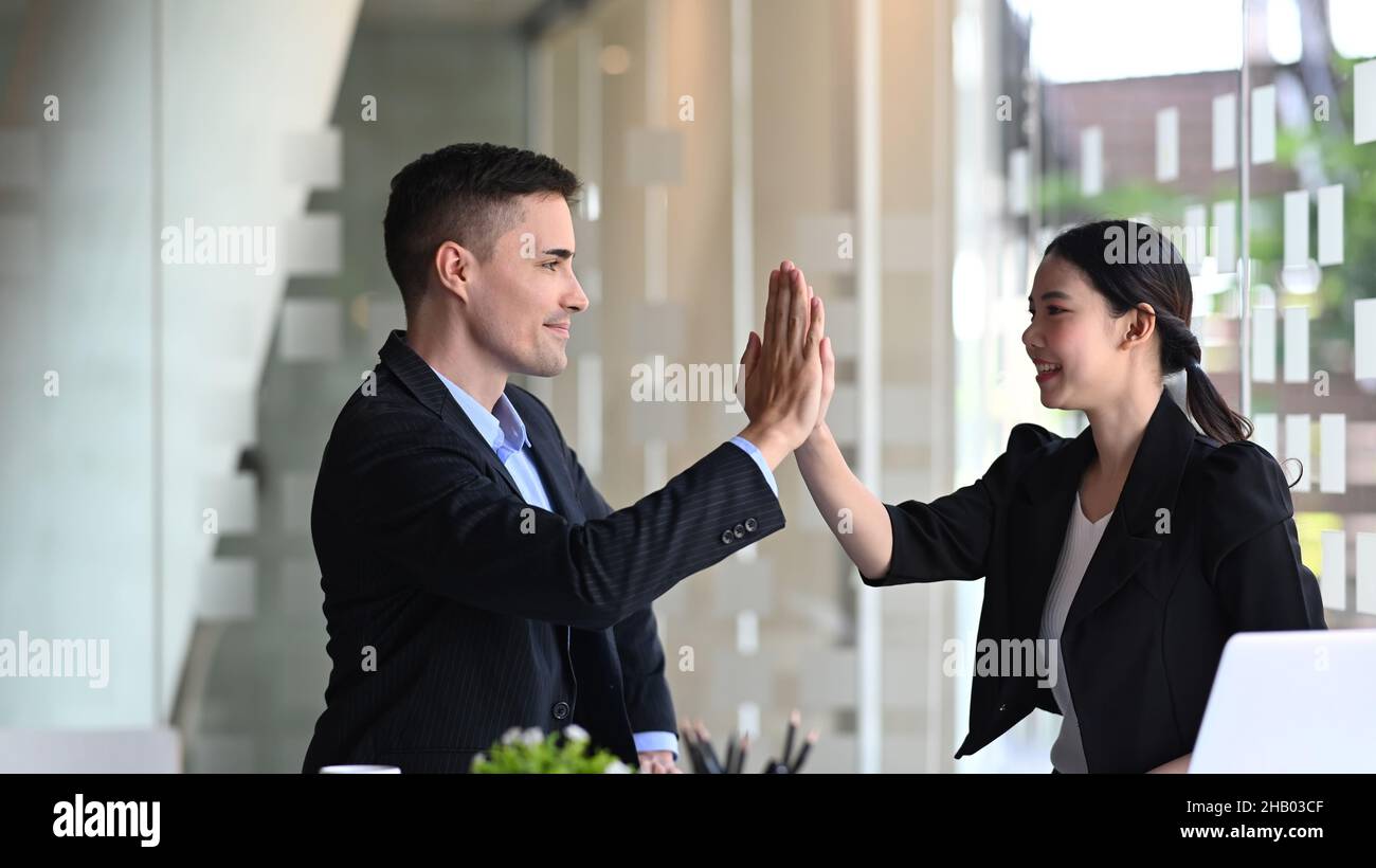 Two happy business people giving high five for celebrating successful ...