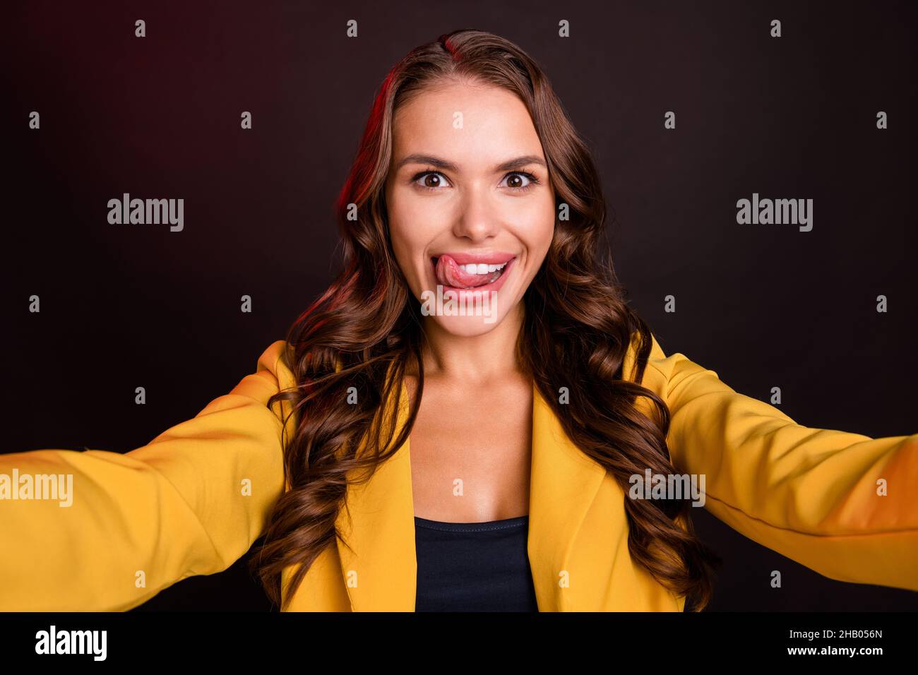 Photo of coquette millennial brunette lady do selfie lick wear yellow jacket isolated on dark color background Stock Photo