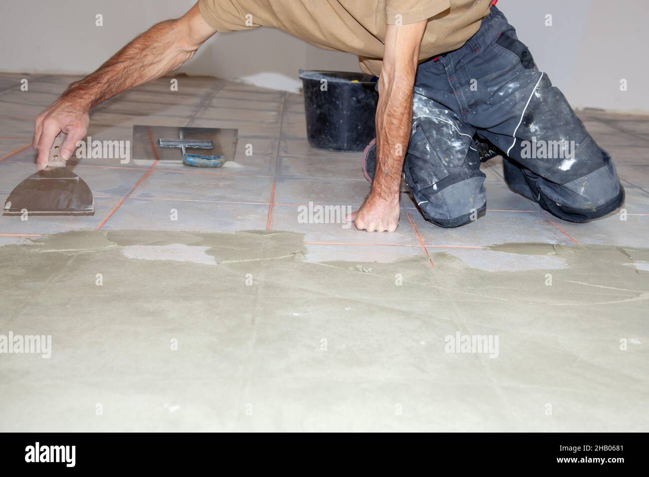 Construction worker leveling compound with putty knife. Renovation