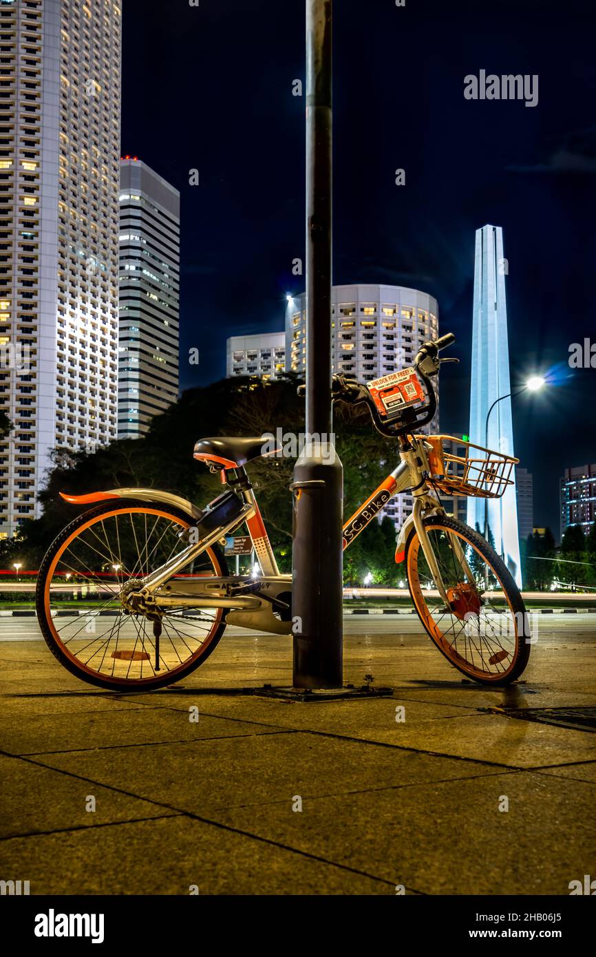 A SG Bike parked beside a lamp pole. One of Singapore's bike sharing service operator. Stock Photo