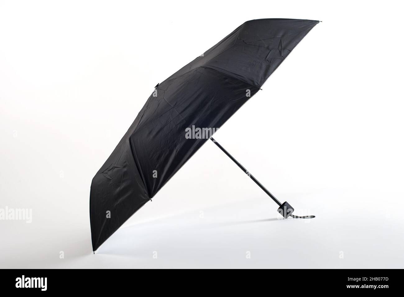 Opened black umbrella isolated on white background. Studio shoot Stock Photo
