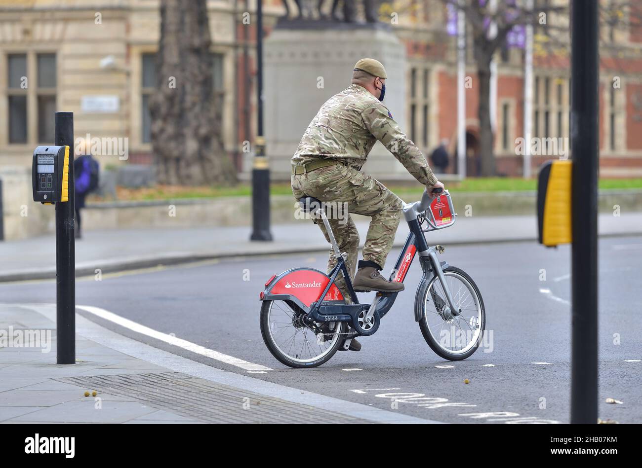 London, England, UK. Soldier in camouflage riding a Santander hire cycle / Boris Bike in Parliament Square Stock Photo