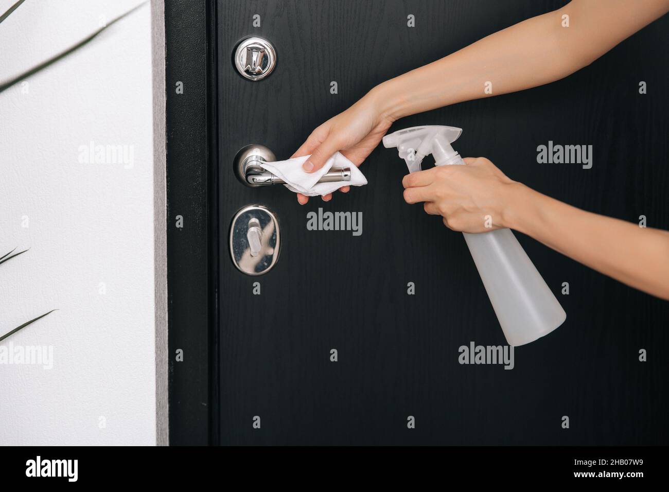Cleaning black door handles with an antiseptic wet wipe and sanitizer