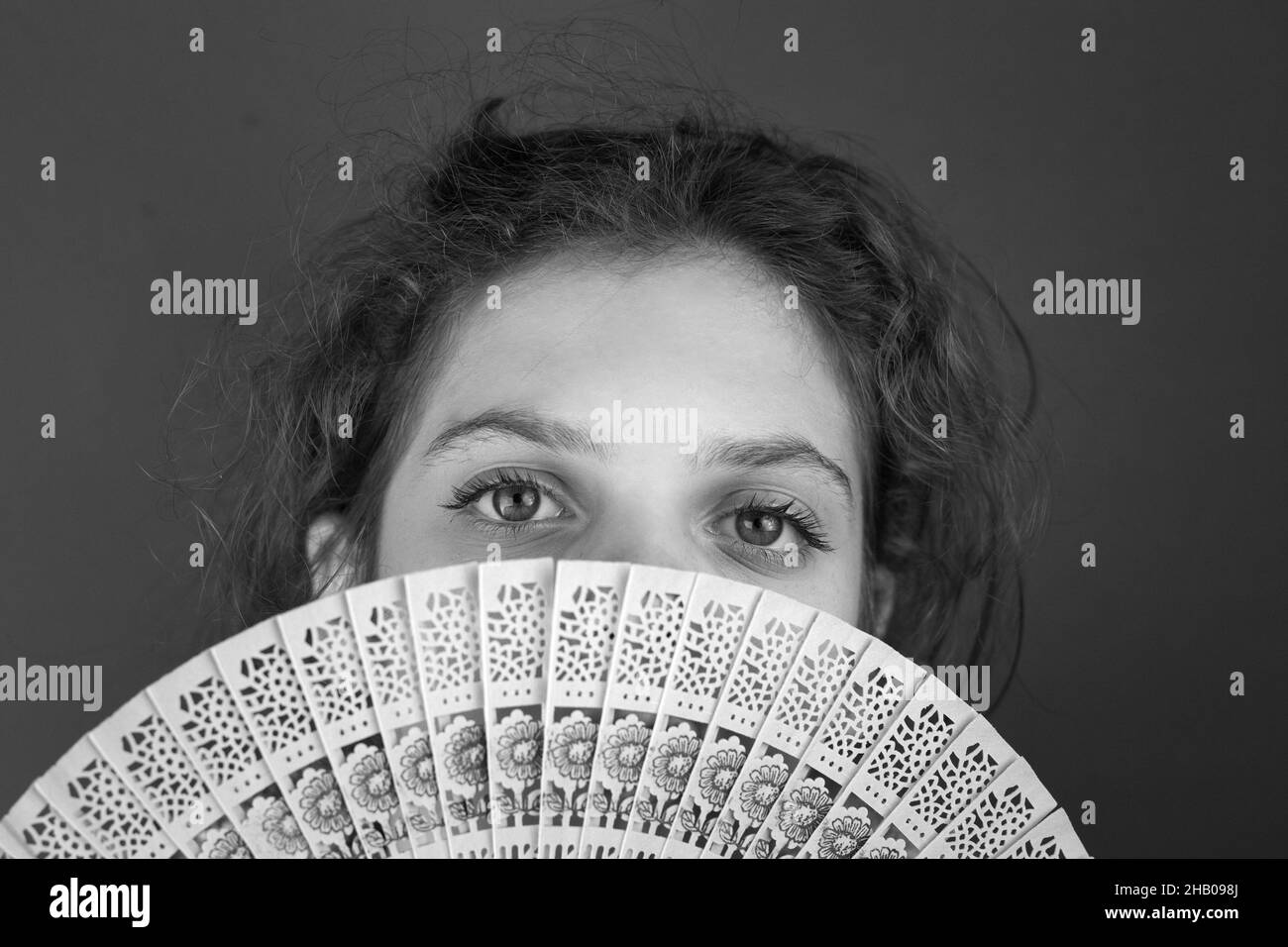 Grayscale shot of a Caucasian female with a partially closed face with a f Stock Photo