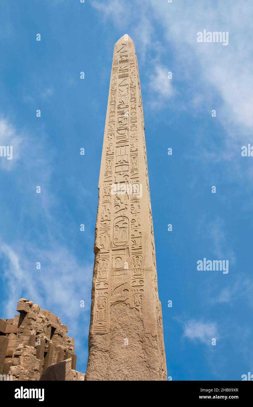 Karnak temple complex in Luxor, Egypt. Ancient stella with hieroglyphs, on blue sky with clouds, Stock Photo