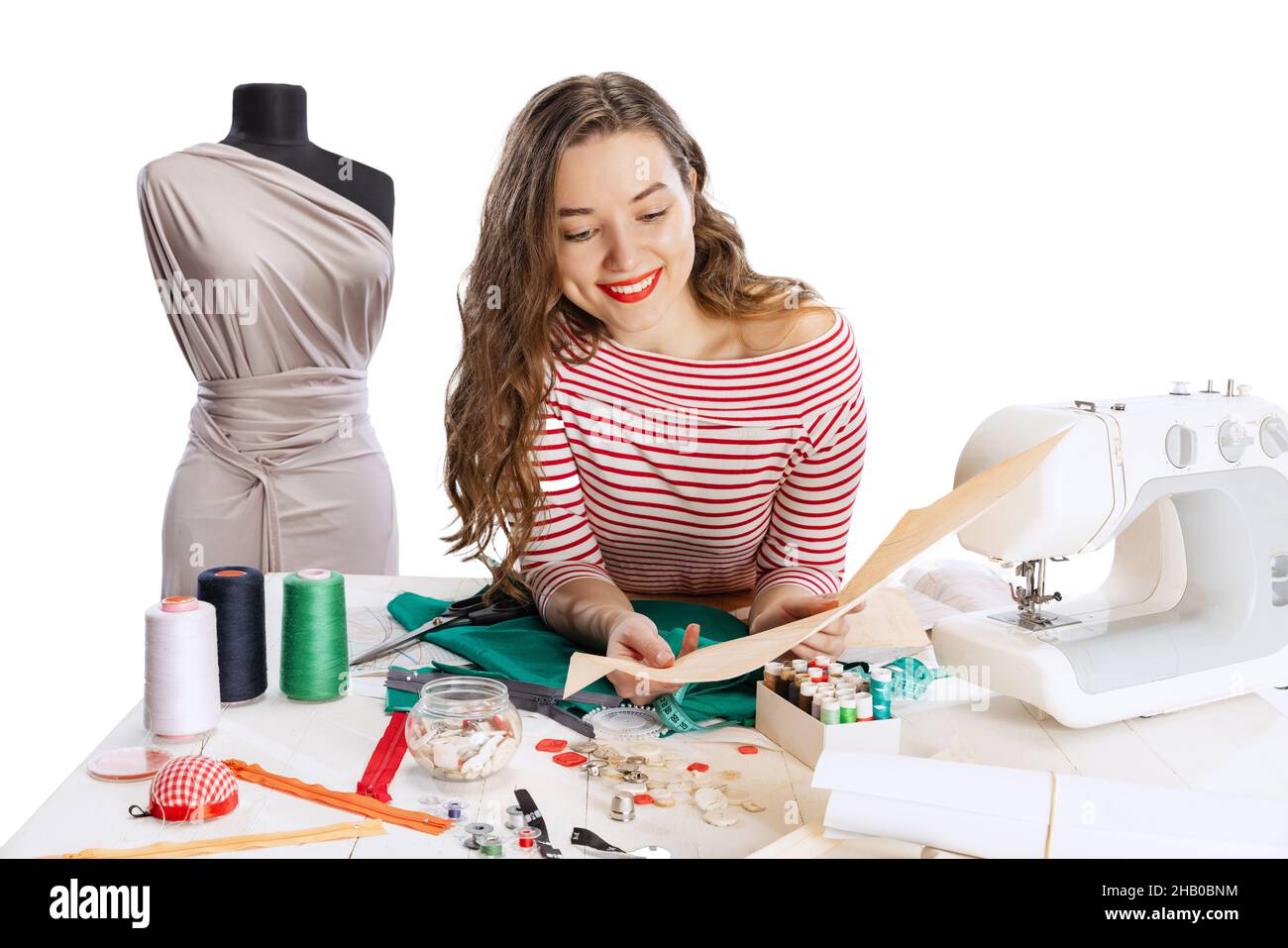 Cheerful beautiful young girl, seamstress, dressmaker working with
