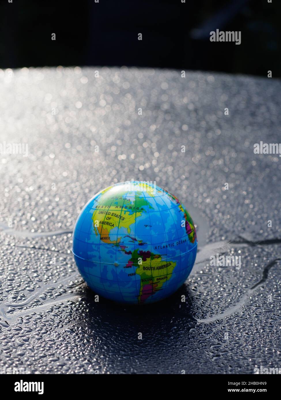 A model globe of the planet Earth against a background of water drops with a blue tint Stock Photo