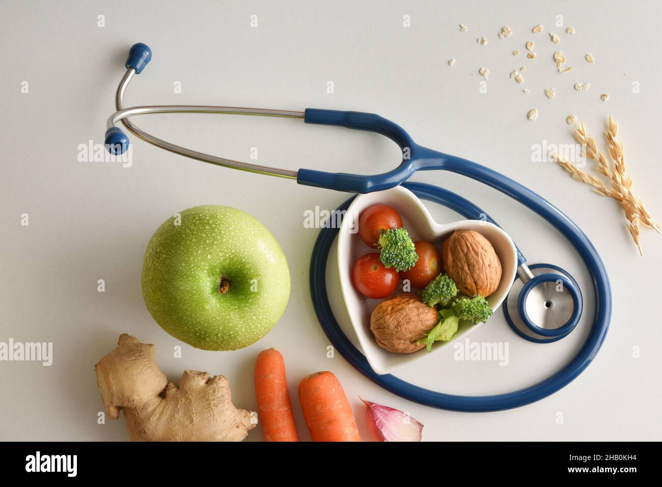 Healthy diet with fruits and vegetables on white table with heart shaped bowl and stethoscope. Top view. Horizontal composition. Stock Photo