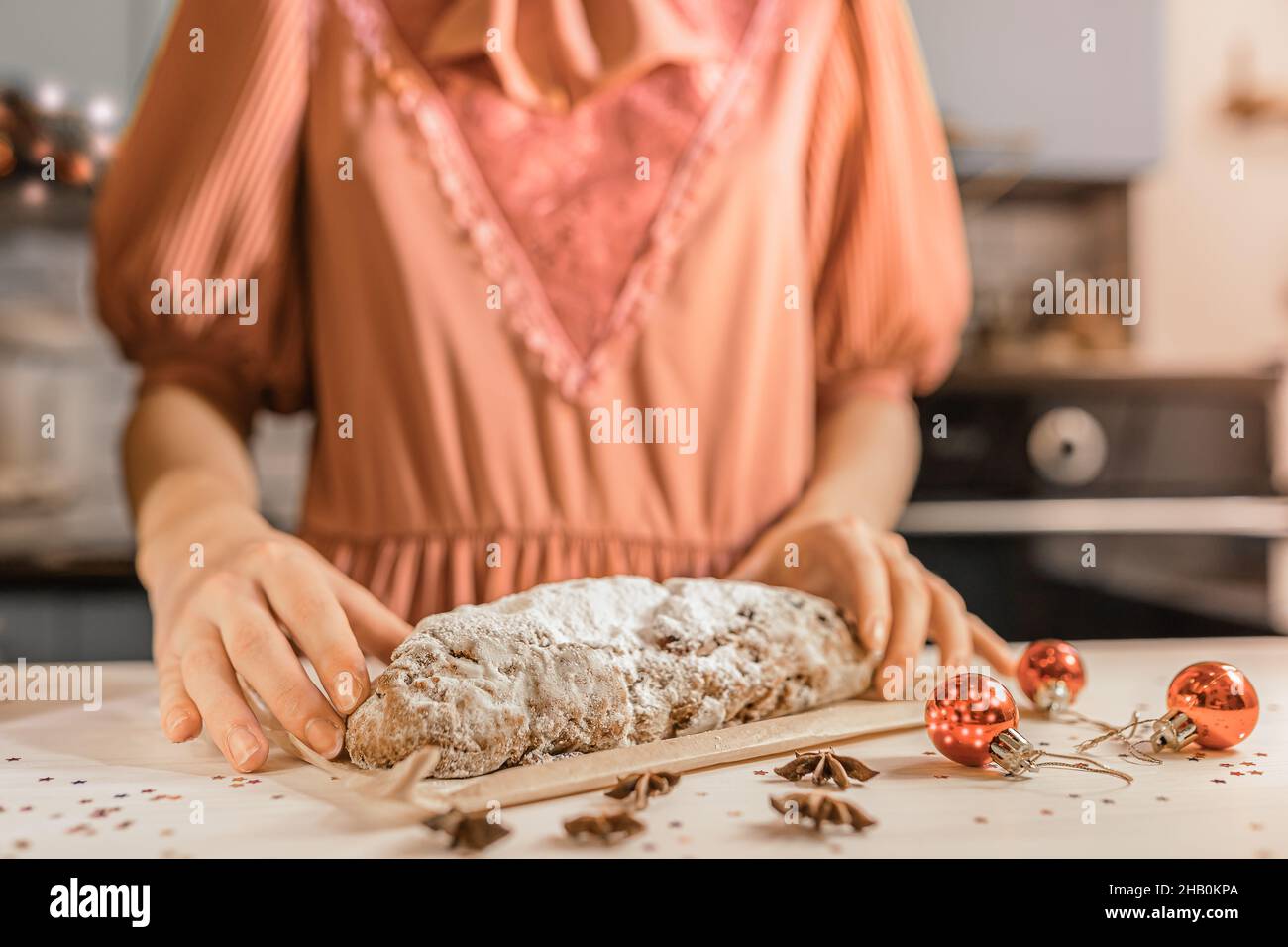 Caucasian girl in festive dress prepared traditional German holiday Stollen cupcake. Christmas eve home holiday atmosphere Stock Photo