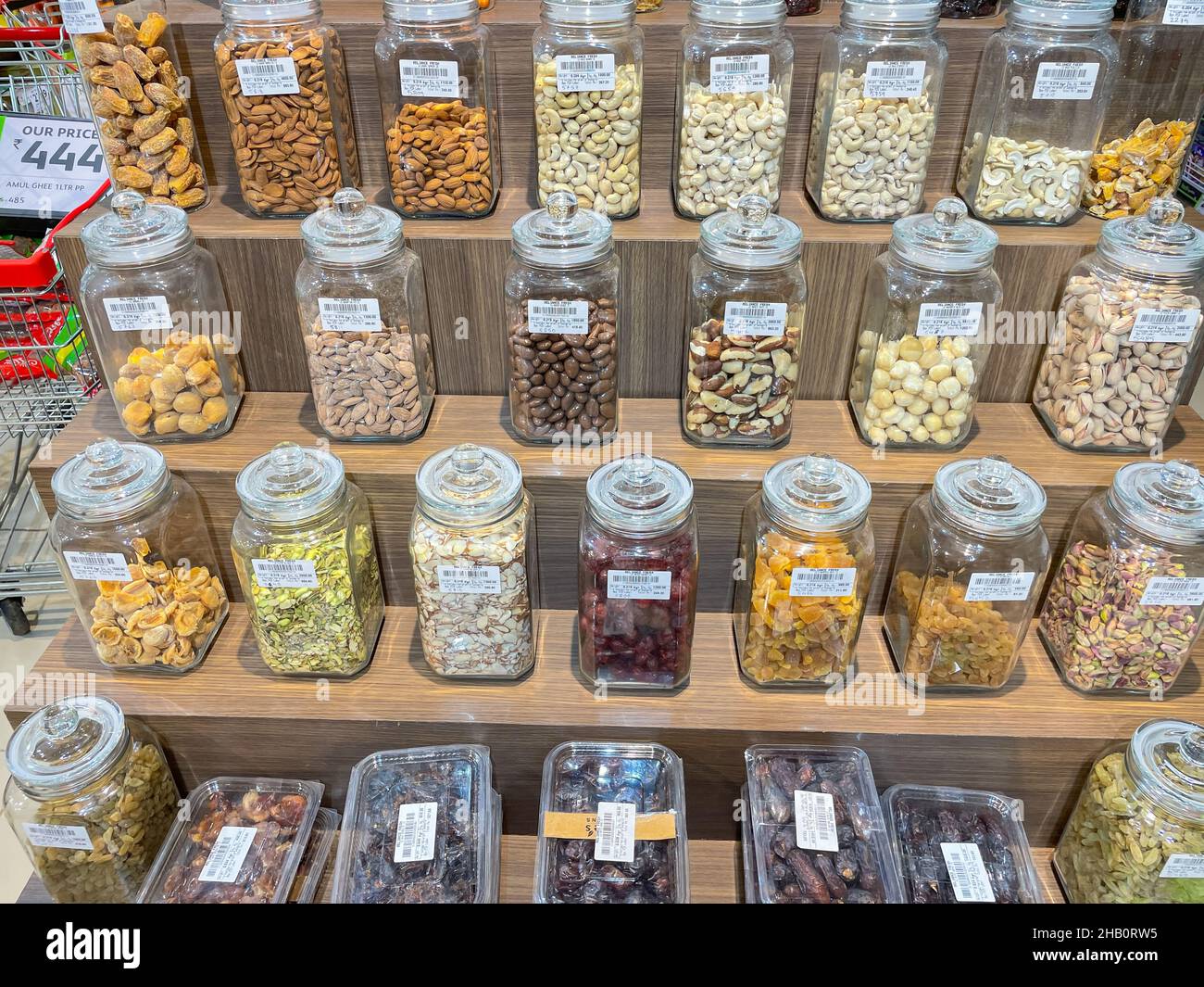 Variety of dry fruits neatly displayed in Glass Jars on Shelves of a