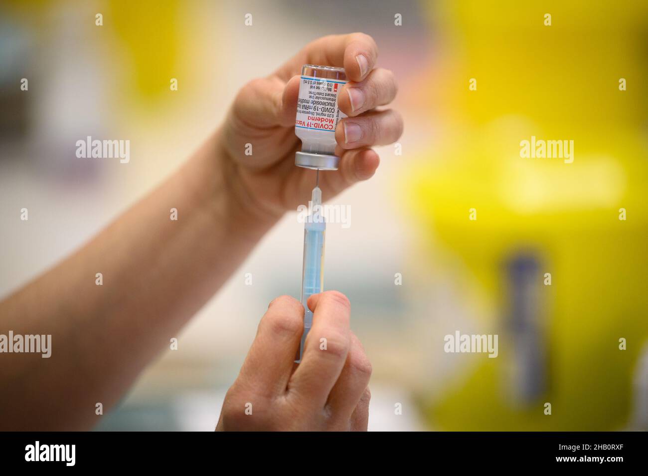 Medical staff and volunteers prepare shots of the Moderna vaccine at a