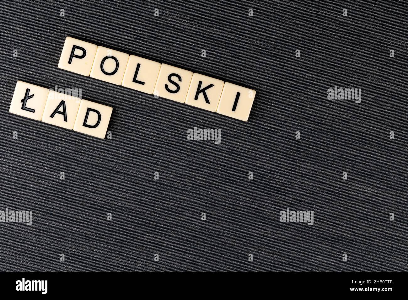 The sentence 'Polski Ład' translated as  'Polish Order' on grey background. New taxation rules in Poland. Photo taken under artificial, soft light Stock Photo
