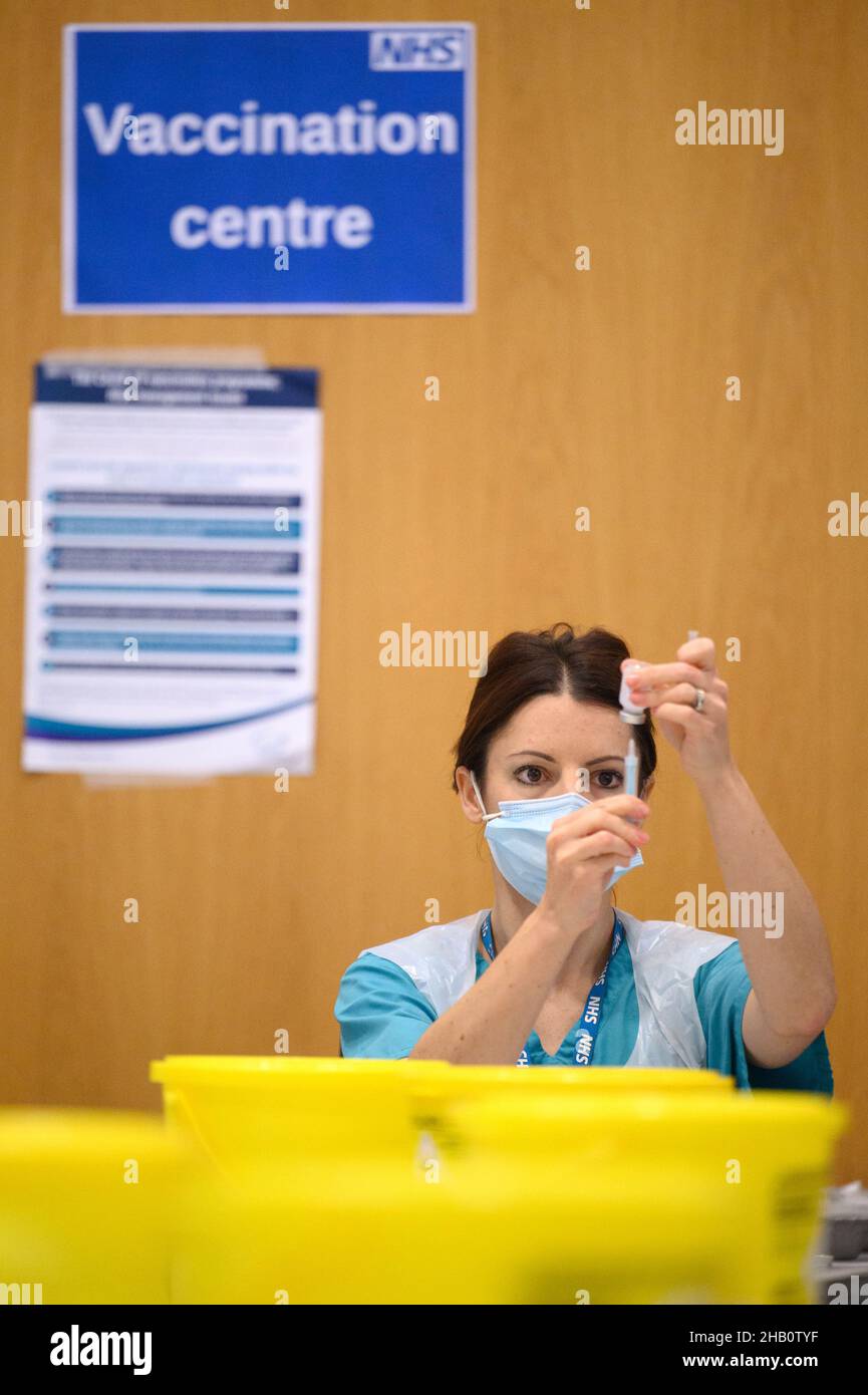 Medical staff and volunteers prepare shots of the Moderna Covid19