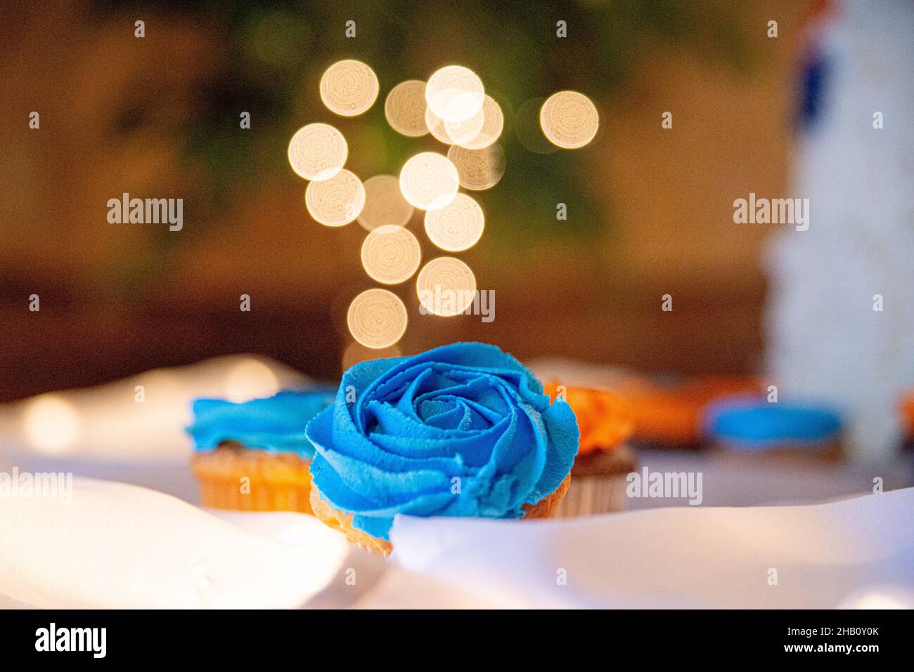 Blue and orange cupcakes on table with bokeh background Stock Photo