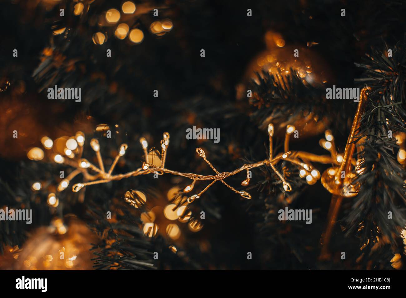 Golden magic glittering bokeh lights of Christmas festive garland. New Year festive background Stock Photo