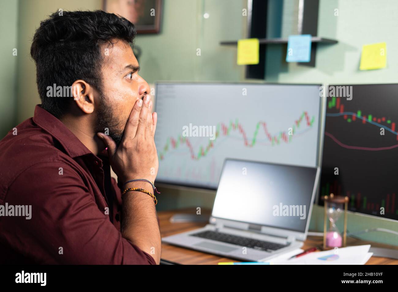 young intraday trader shocked due to sudden market crash while trading - concept of financial loss, risk in share or crypto markets Stock Photo