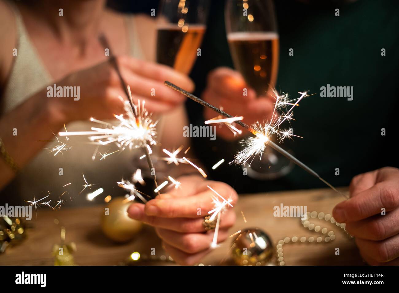 happy couple holding sparkles and champagne glasses New Year party Stock Photo