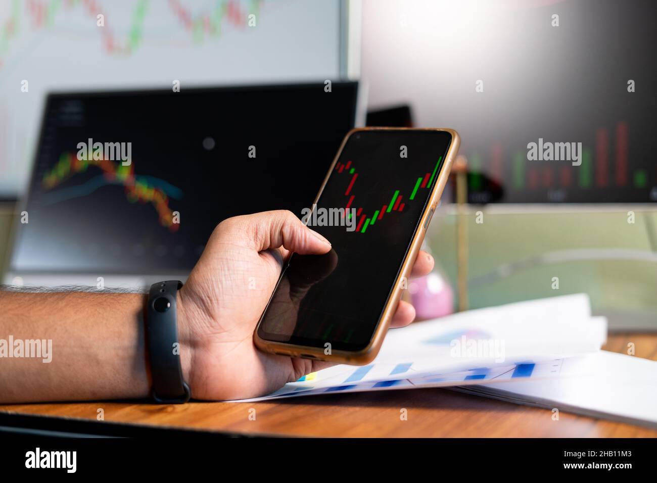 Close up of trader hands watching stock market charts on mobile phone app - concept of Investing money on shares using technical analysis, trading or Stock Photo