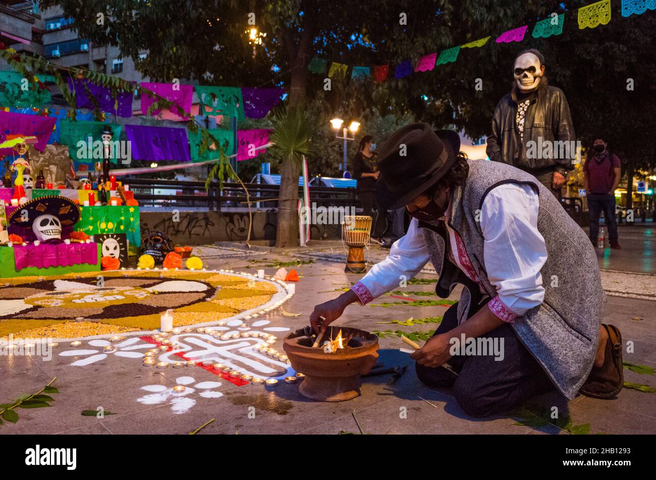 Granada, Andalusia, Spain : A Mexican man lights an incense fire by the altar on the oDay of the Dead. Stock Photo